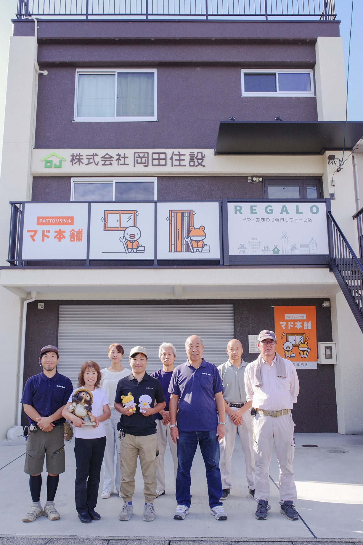 会社の前でスタッフの全員写真